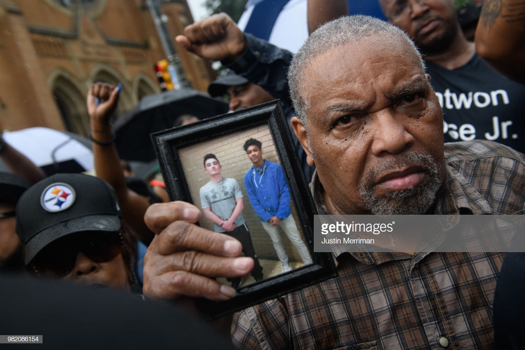  A man holds a photo of Antwon Rose as he joins a protest for the police shooting of Rose during a Juneteenth celebration on June 23, 2018 in Pittsburgh, Pennsylvania. Rose, an unarmed black teenager, was shot Tuesday night, leading to protests and o