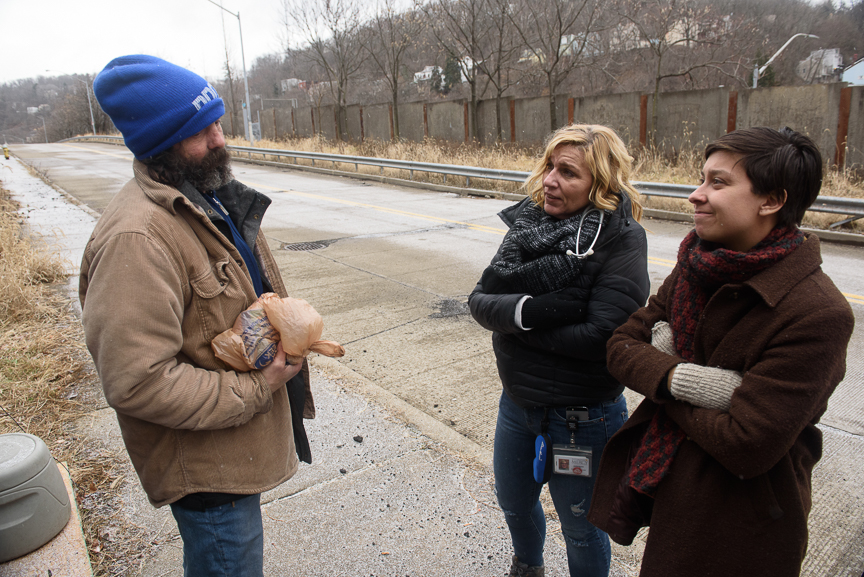  Operation Safety Net's Janice Kochik, a nurse practitioner (center), and Calla Kainaroi, an outreach specialist (right), talk with Steve Balog to check on his needs on Jan. 24, 2018, at a transitional camp for people experiencing homelessness near t