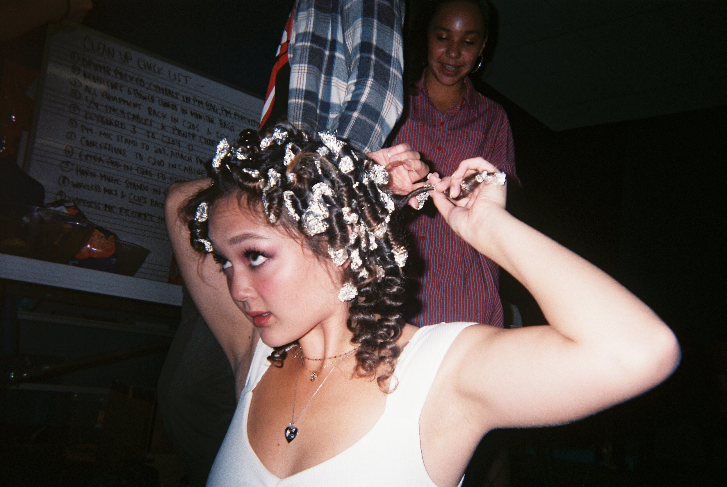 Claire Serrano (PM '20) gets ready for the show by creating a totally 80's hairdo.
