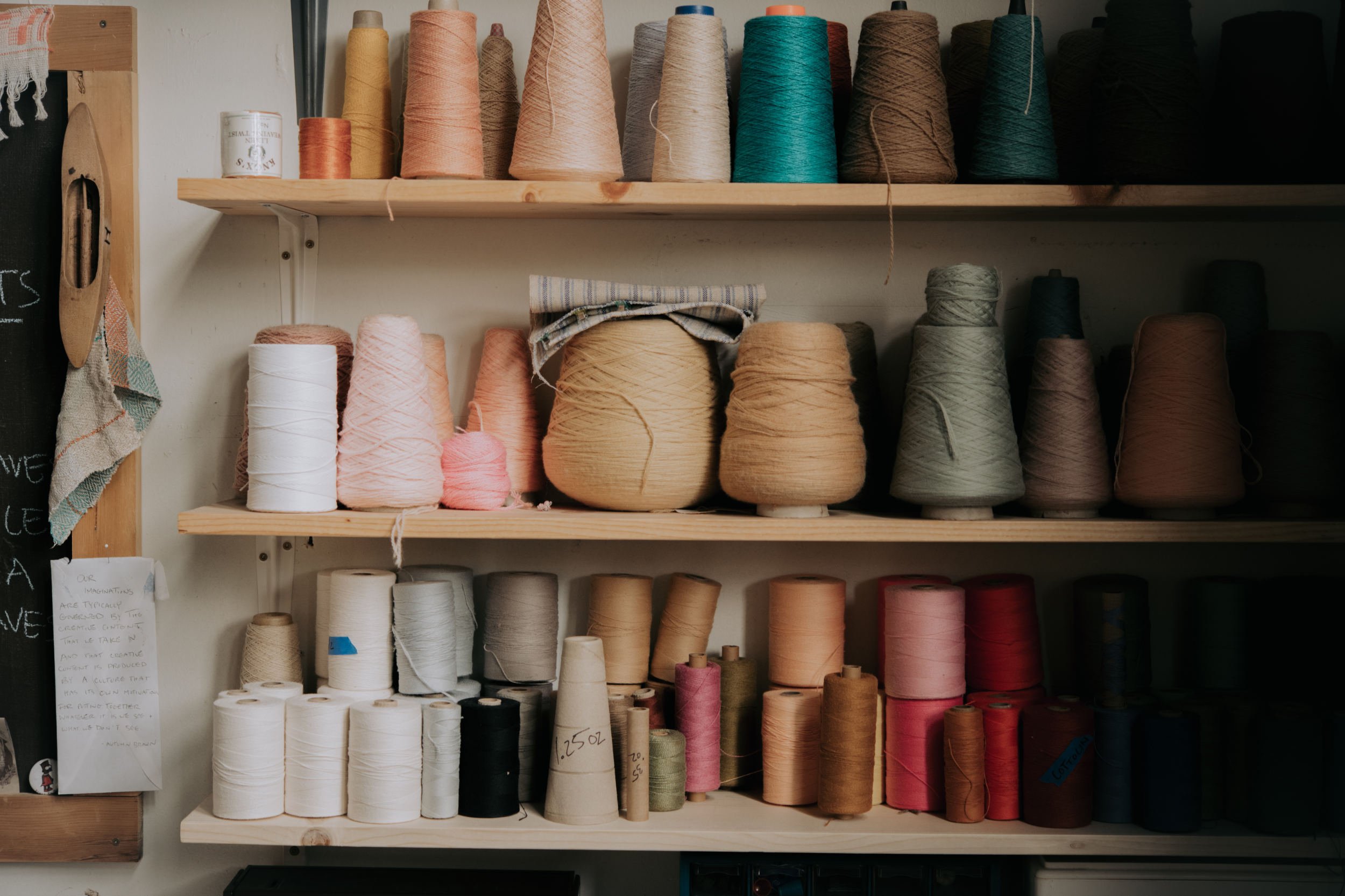 Cones of weaving yarn on shelf.jpg