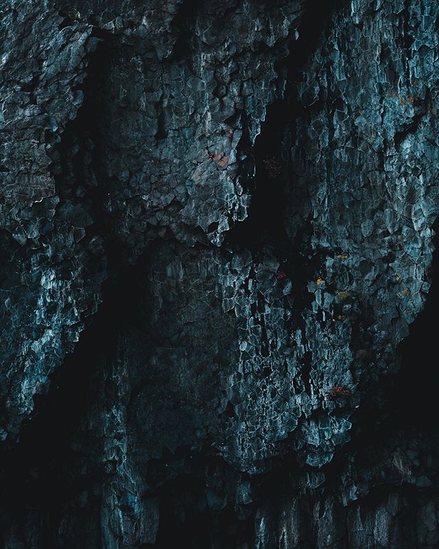 Layered basalt rock formations. 
With a sheer drop down beneath the oceans surface, we drifted along in our sailing boat just meters away from the base of this mountain wall in East Greenland. With strange rock formations stretching hundreds of meter