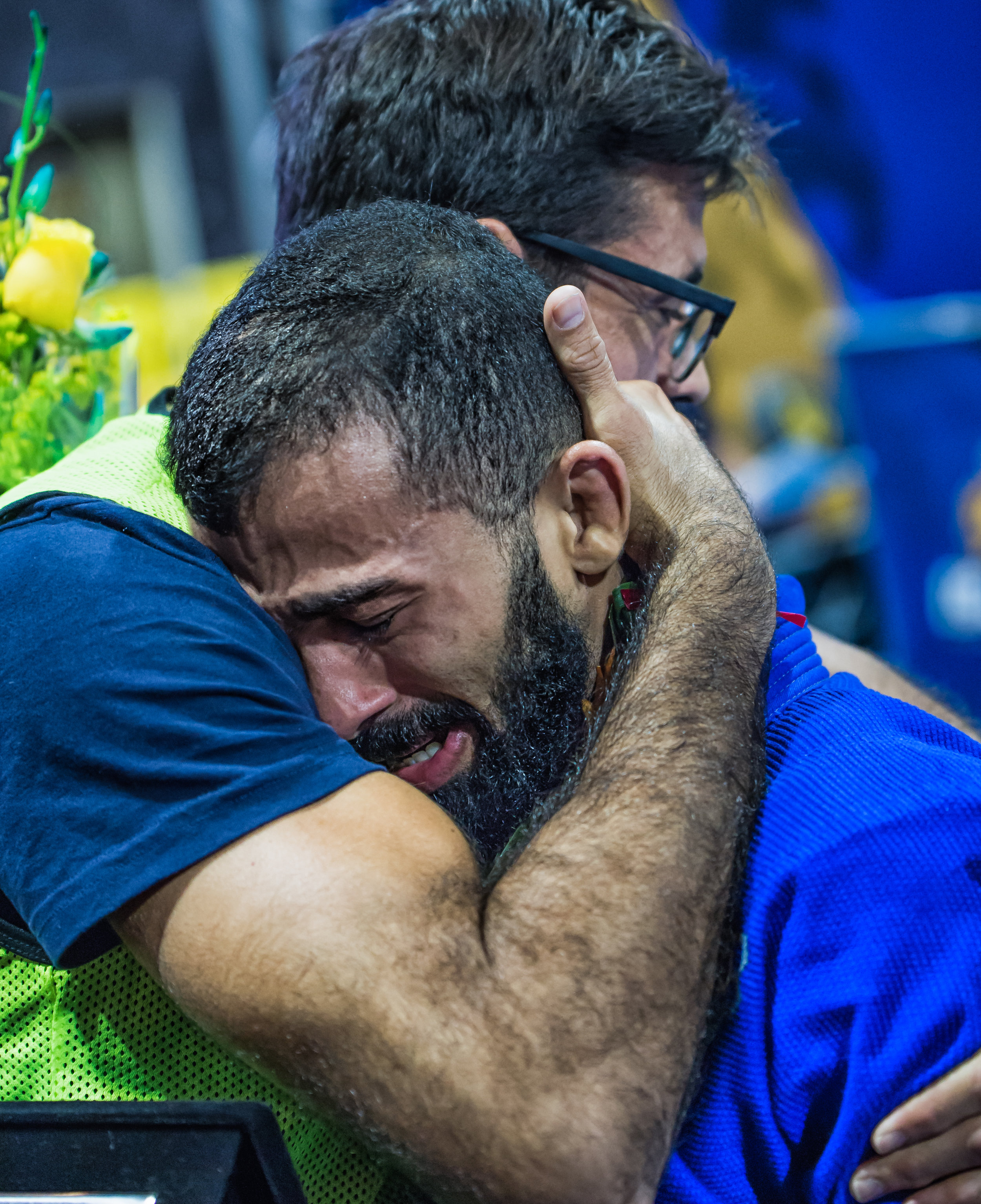 Bruno Malfacine falls into the embrace of his coach, Mario Reis after stepping off the top of the podium for a record 10th time.