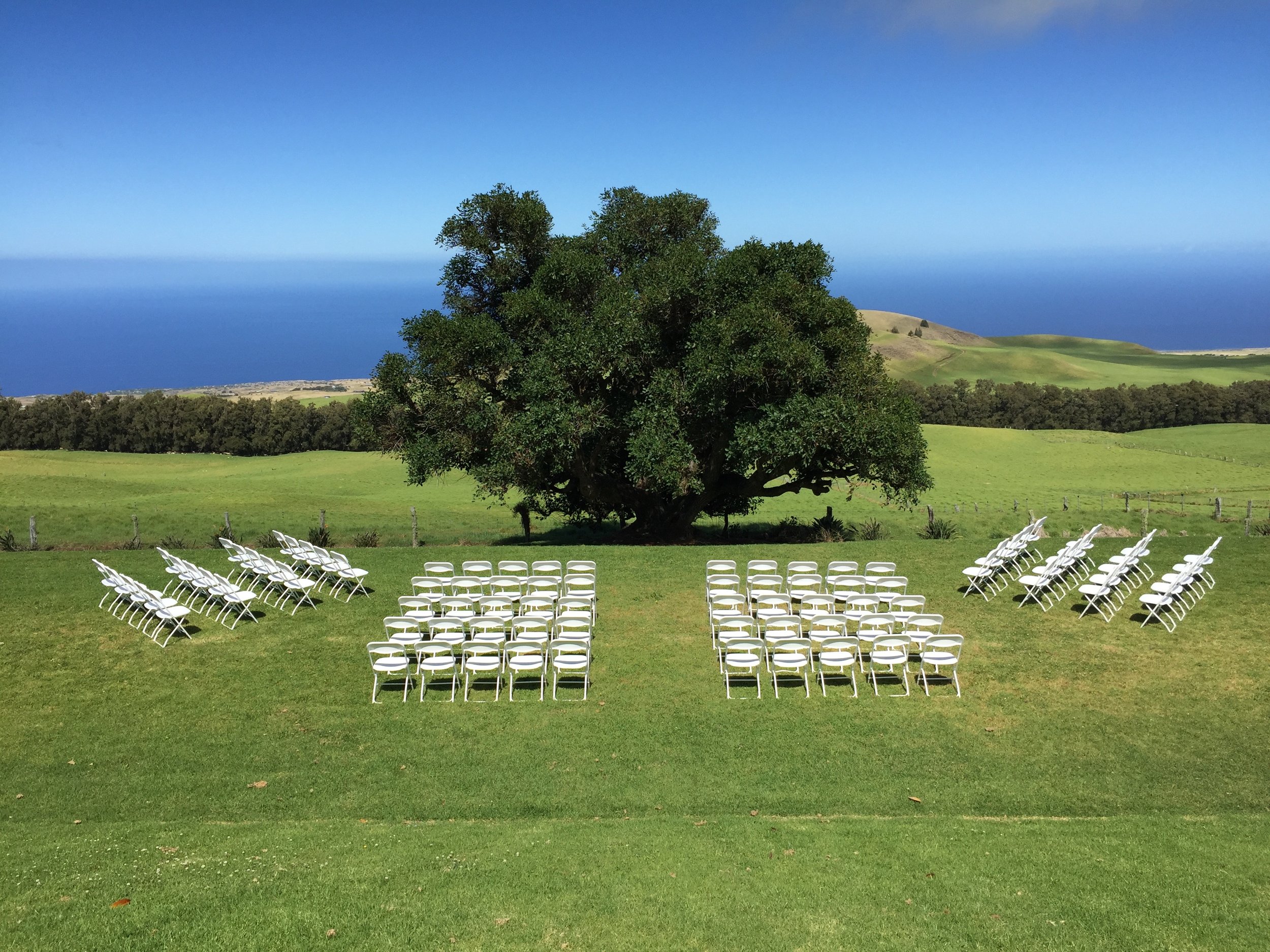 White Plastic Folding Chairs for ceremony at Kahua Ranch .