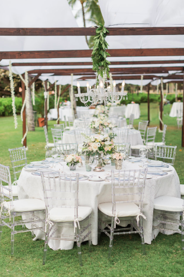 Clear Chiavari Chairs under a Dark Wood Dinning Canopy and Chandelier.Photo Sea Light Studios