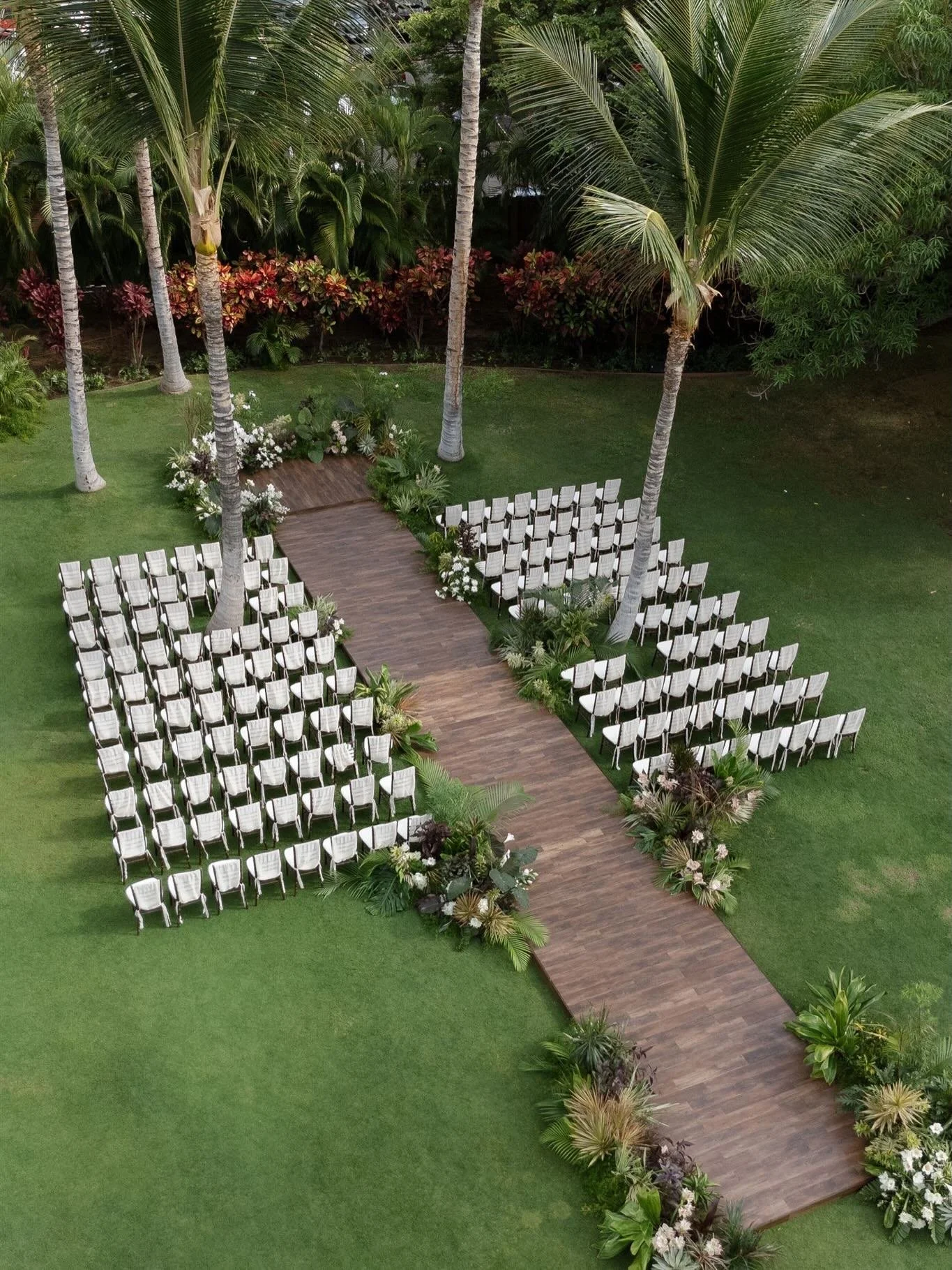 Beautiful wedding reception and ceremony at Mauna lani Auberge. Coordinated and designed by Sophia Goff. Featuring our 40x100 sail cloth tent with custom fabric leg draping, dark wood chiavari chairs, dark wood farm tables, custom lauhala bar fronts,