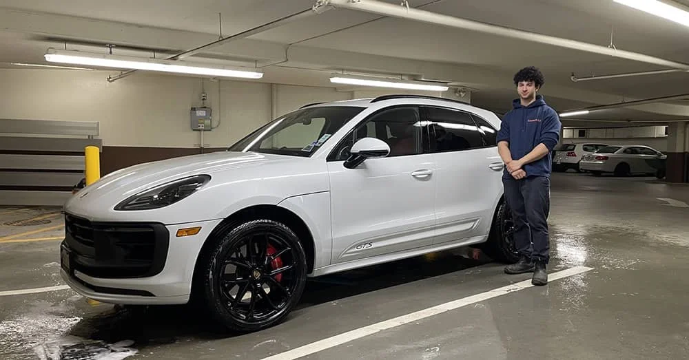 White Porsche SUV after exterior detailing service with Clean My Car technician in an underground parking garage in Vancouver.