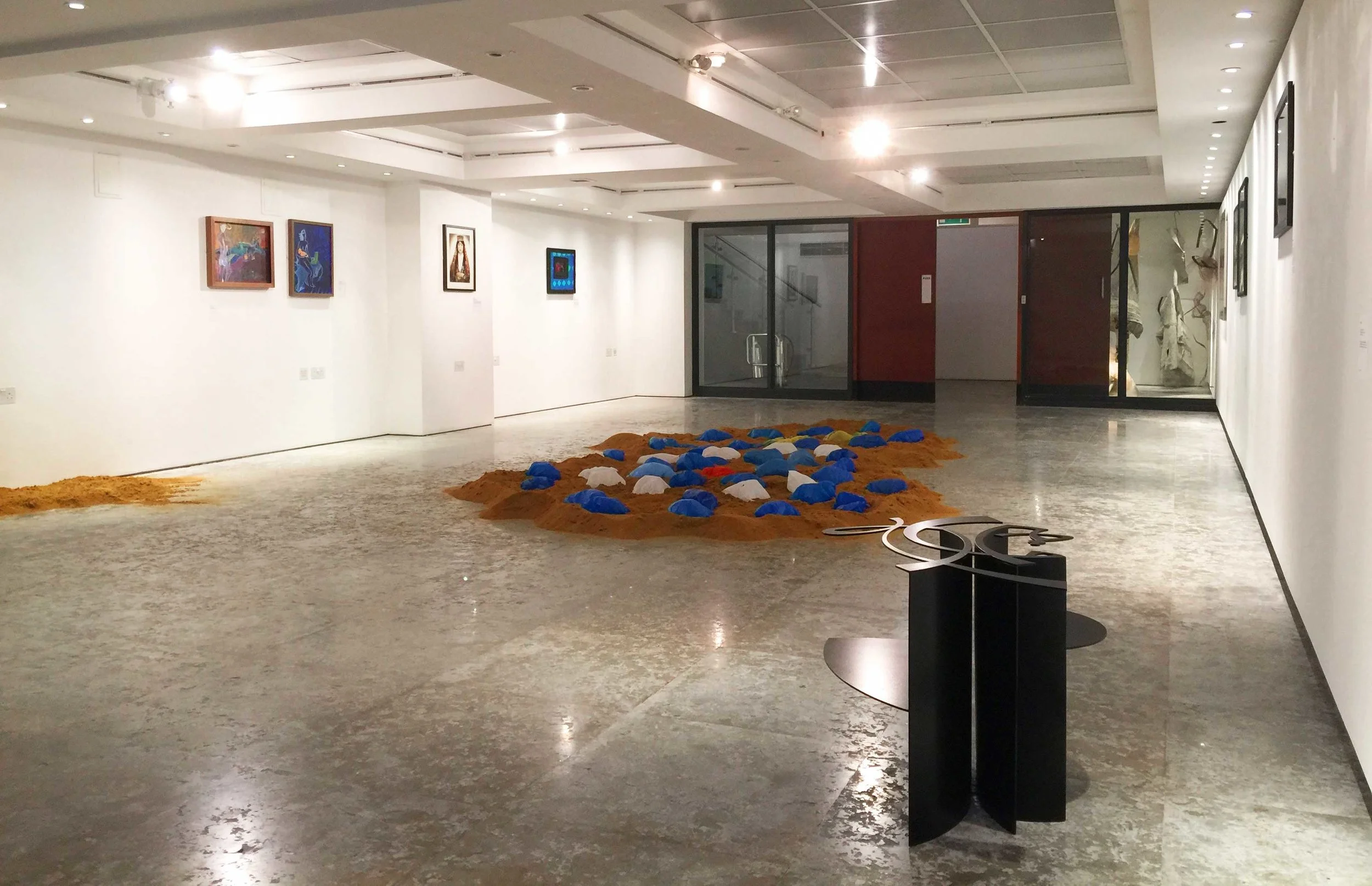 Low lying objects and installations optimise a room with low ceiling height, and vertical objects can be used to suggest an itinerary to visitors. Transparent walls carry the eye out of the room towards the next piece (Moments of Expulsion © Jo Scorah. 'This is Not a Table' © Dia Batal (foreground), 'Foreign Bodies' © Souheil Sleiman (central floor installation)