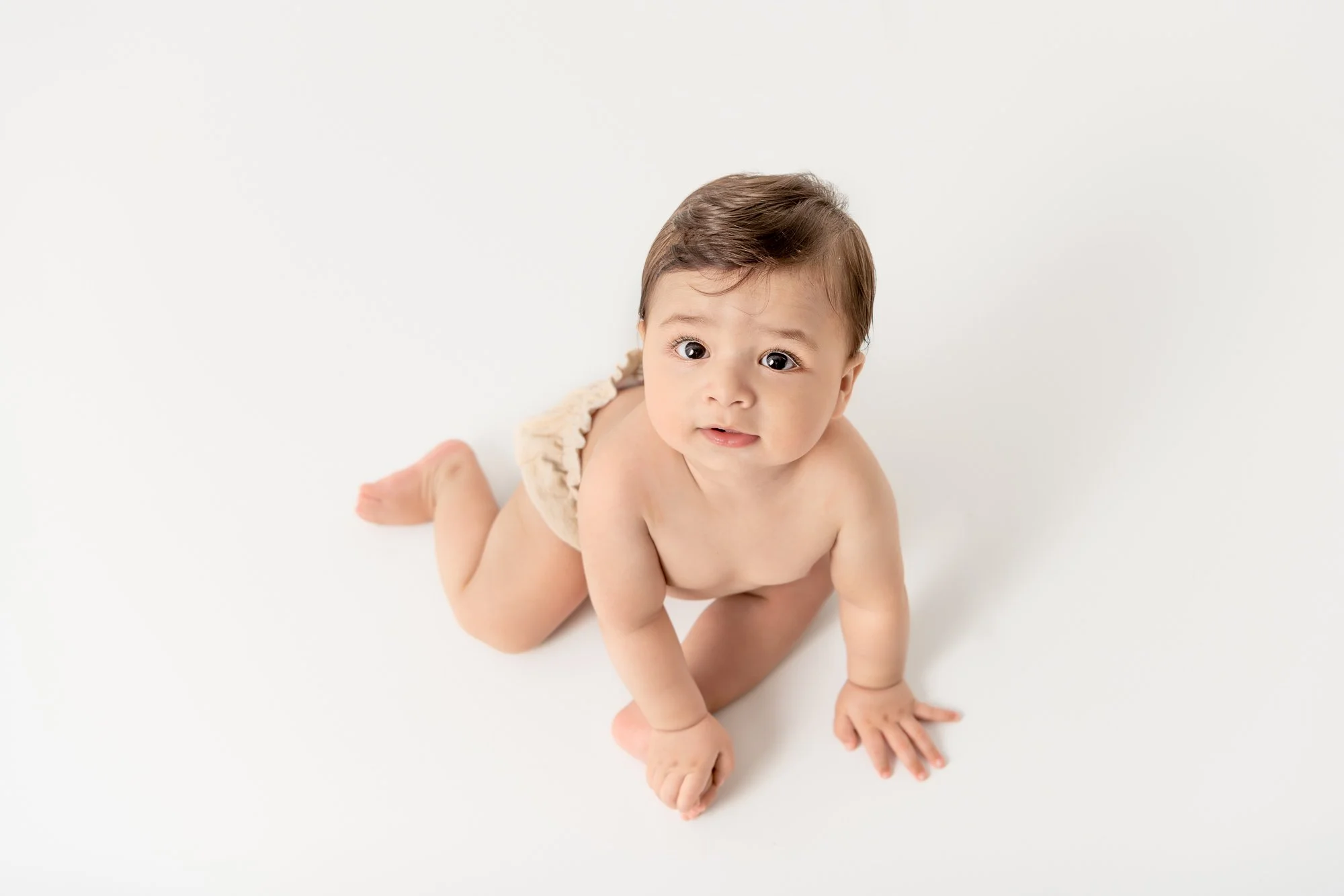  Little boy with big dark eyes and brown think hair looks up at a Northern New Jersey Studio by Nicole Hawkins Photography a professional baby photographer. studio baby photographers New Jersey photography studios #nicolehawkinsphotography #nicolehaw