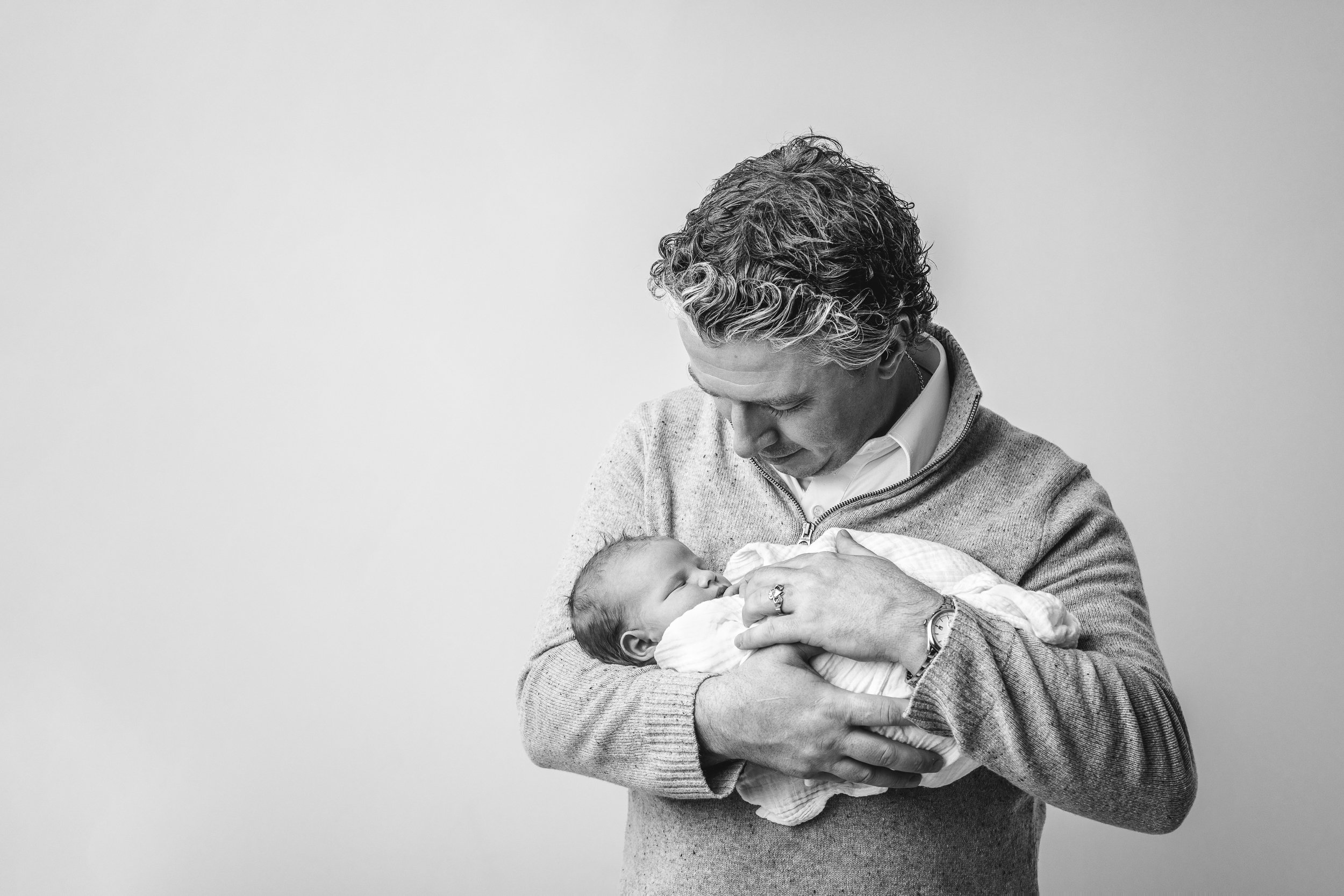 Father holding his baby girl and looking down at her in a black and white photo captured by Nicole Hawkins Photography a New Jersey photographer. black and white photo father and baby father and daughter daddy daughter #nicolehawkinsphotography #nic