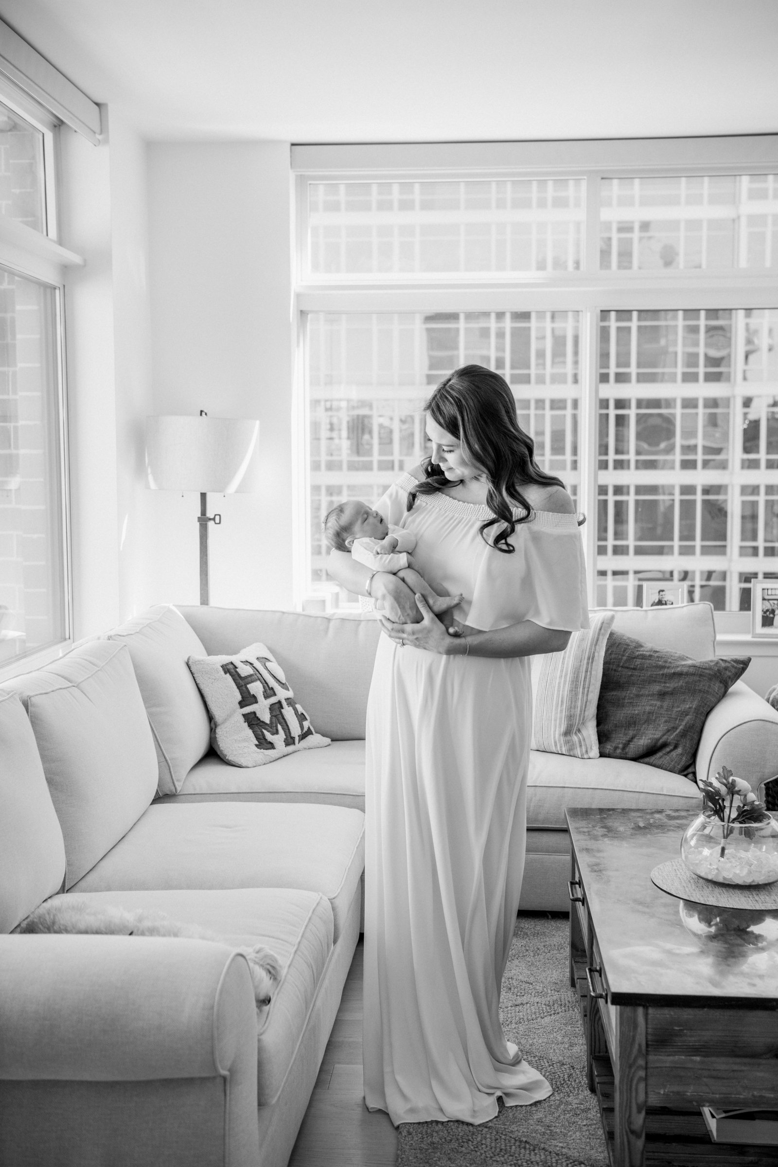  Black and white portrait of a mother's love holding her brand new baby in her living room captured in New Jersey by Nicole Hawkins Photography. brand new baby first baby motherhood captured in a portrait #nicolehawkinsphotography #nicolehawkinsnewbo