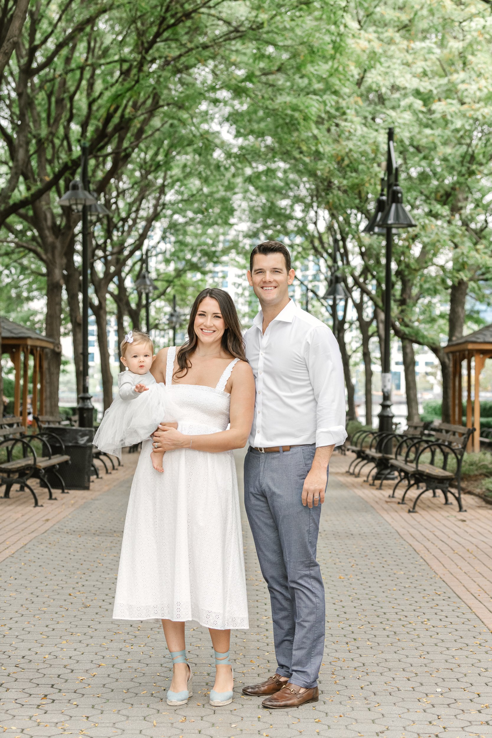  A family with a young girl takes portraits in New Jersey by Nicole Hawkins Photography. family portraits NJ family pics white outfits #nicolehawkinsphotography #newjerseyphotographers #familyphotographer #6monthportraits #NJfamilyphotos 