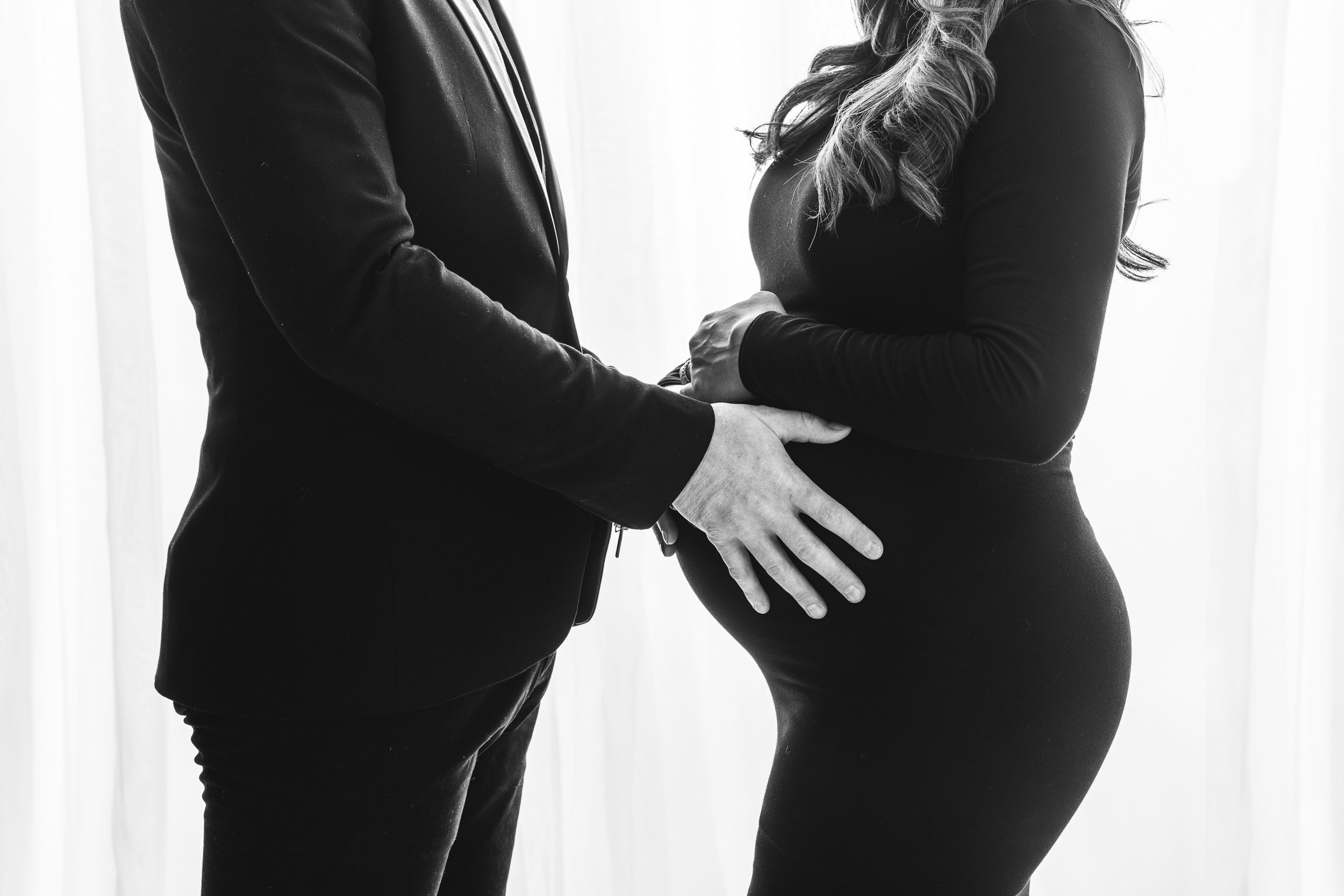  Nicole Hawkins Photography captures a husband and wife with their hands on her belly bump. Belly bump husband and wife bright NJ studio #NicoleHawkinsPhotography #maternitysession #NJmaternityphotographer #NewJerseyphotographers #maternityphotos 