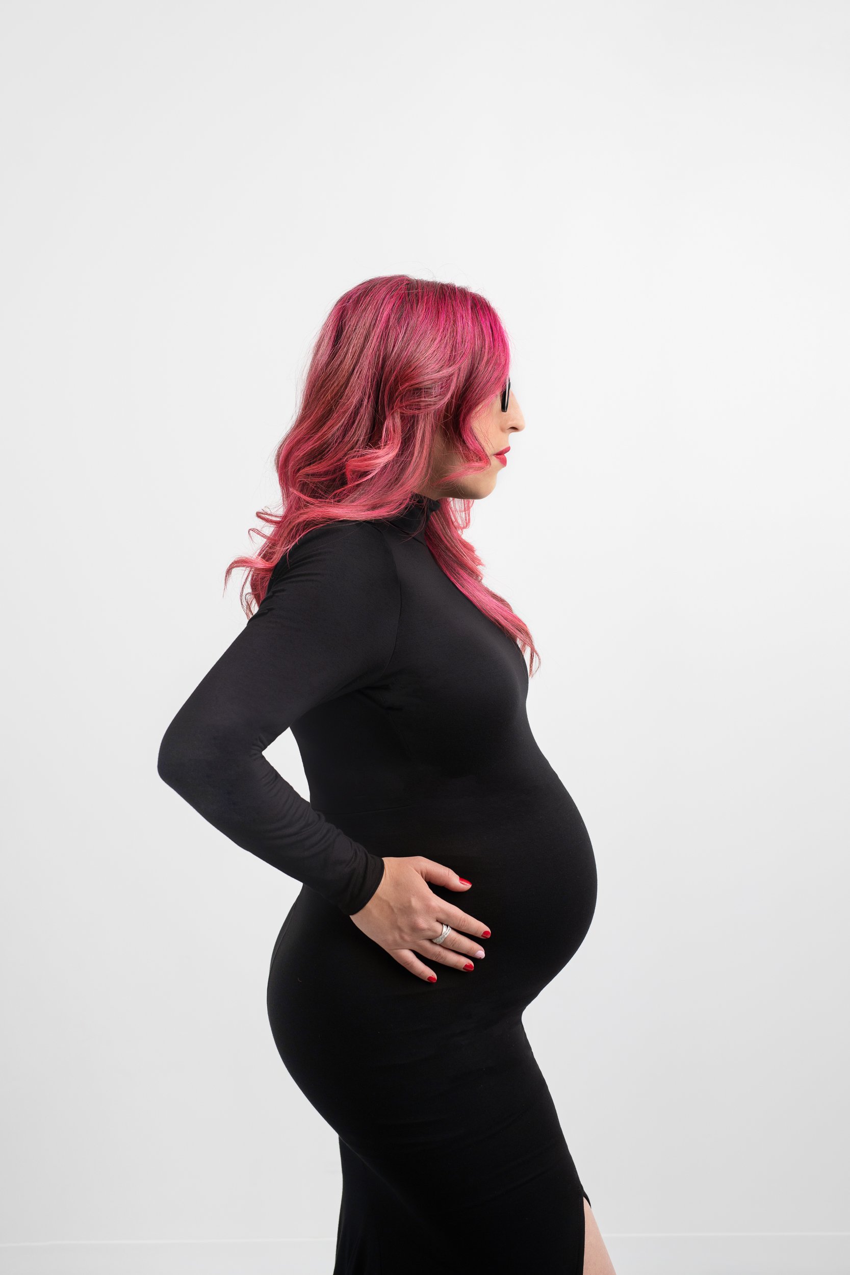  A mother with pink hair holds her bump and her silhouette is captured by Nicole Hawkins Photography. pregnancy silhouette pics #NicoleHawkinsPhotography #maternitysession #NJmaternityphotographer #NewJerseyphotographers #maternityphotos 