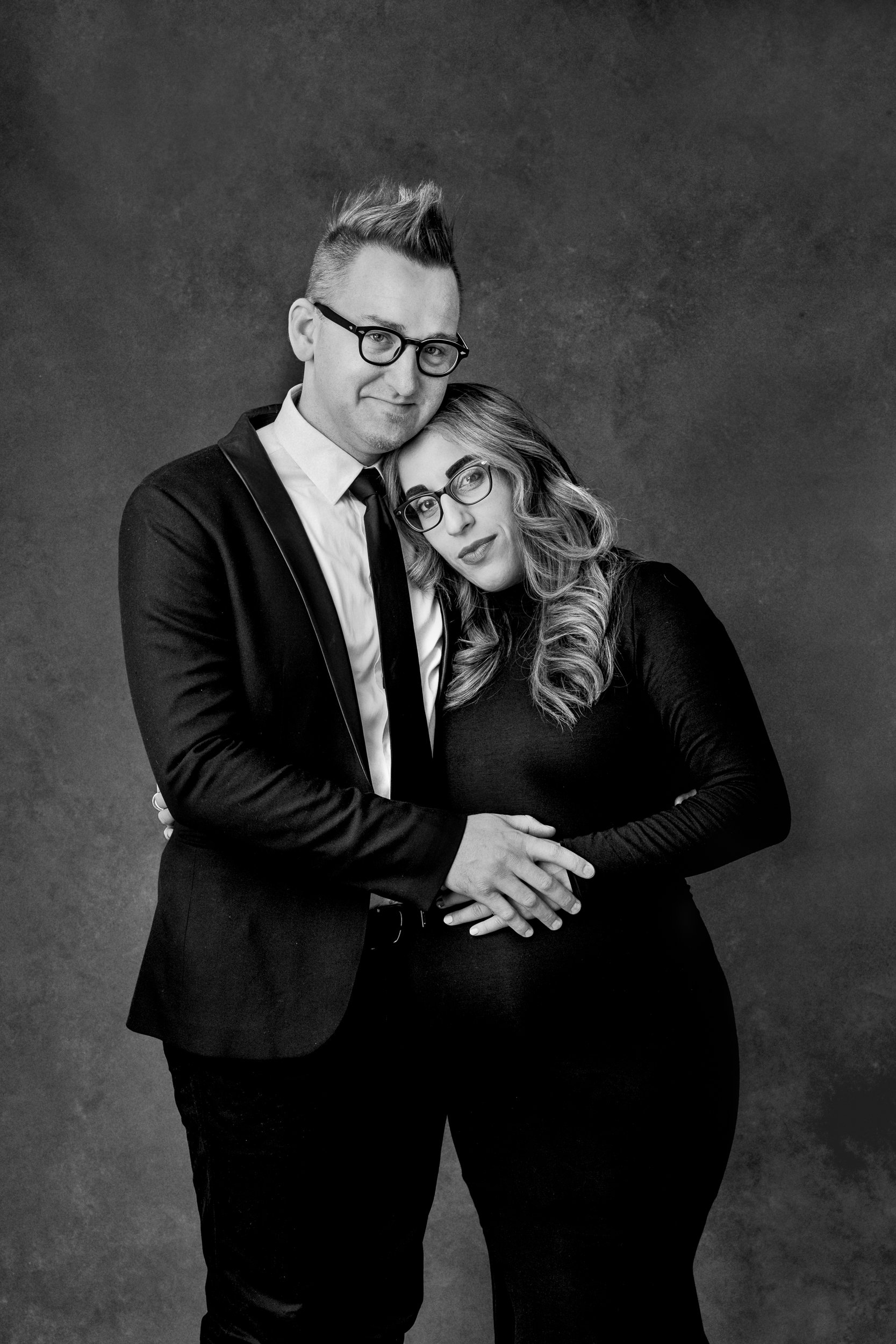  NJ photographer Nicole Hawkins Photography takes a studio maternity session of a couple wearing black. couple with glasses black and white #NicoleHawkinsPhotography #maternitysession #NJmaternityphotographer #NewJerseyphotographers #maternityphotos 