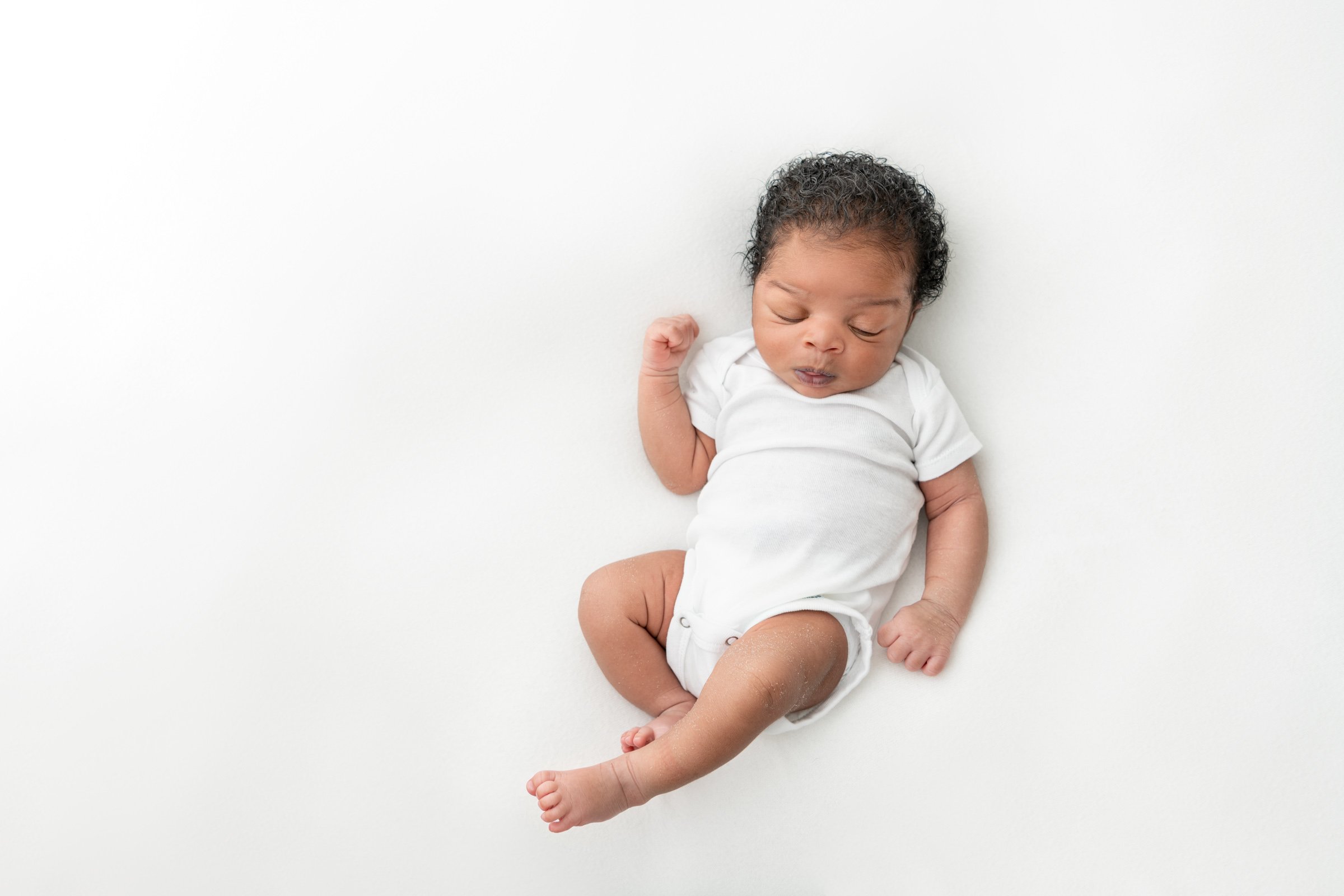  Nicole Hawkins Photography a New Jersey photographer captures a baby boy in a onesie. newborn portraits minimalist newborn photography #nicolehawkinsphotography #NJbabyphotography #newbornportraits #NewJerseyStudioPhotography #newbornsession 