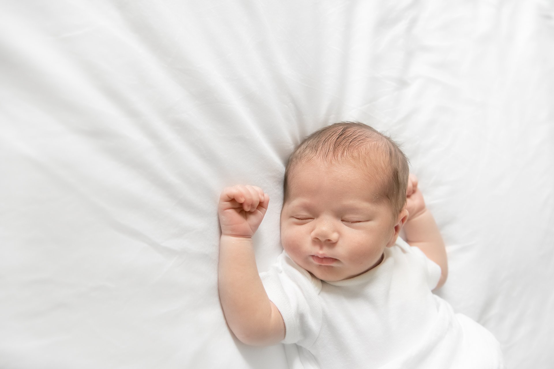  Sleeping baby on a white sheet in a bright light studio by Nicole Hawkins Photography. New York City Newborn Photographer sleeping baby #nicolehawkinsphotography #NYCbabyphotography #newbornportraits #NewYorkStudioPhotography #newbornsession 