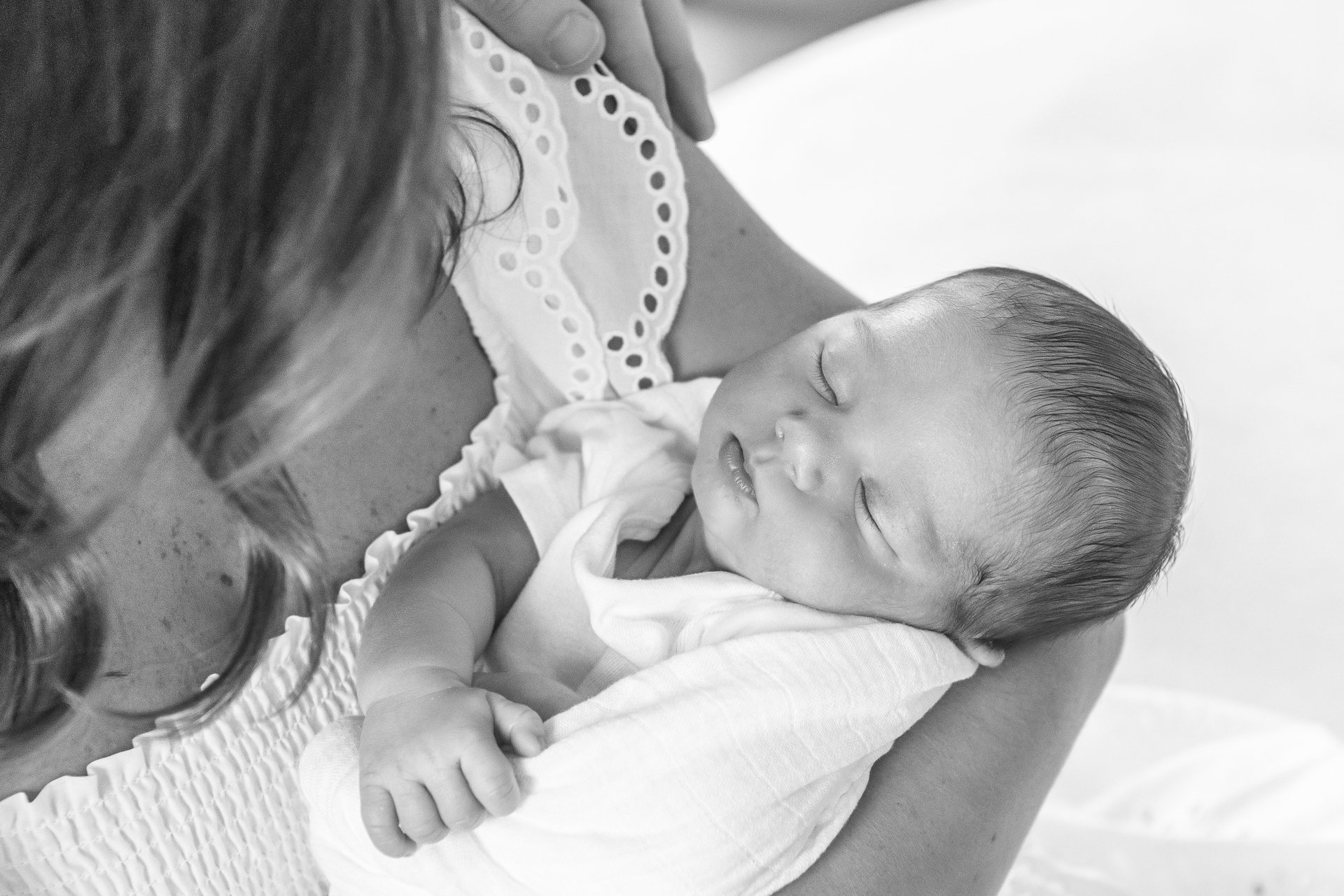  The baby boy wrapped in a blanket is being held in his mother’s arms in New York City by Nicole Hawkins Photography. sleeping newborn photography #nicolehawkinsphotography #NYCbabyphotography #newbornportraits #NewYorkStudioPhotography #newbornsessi