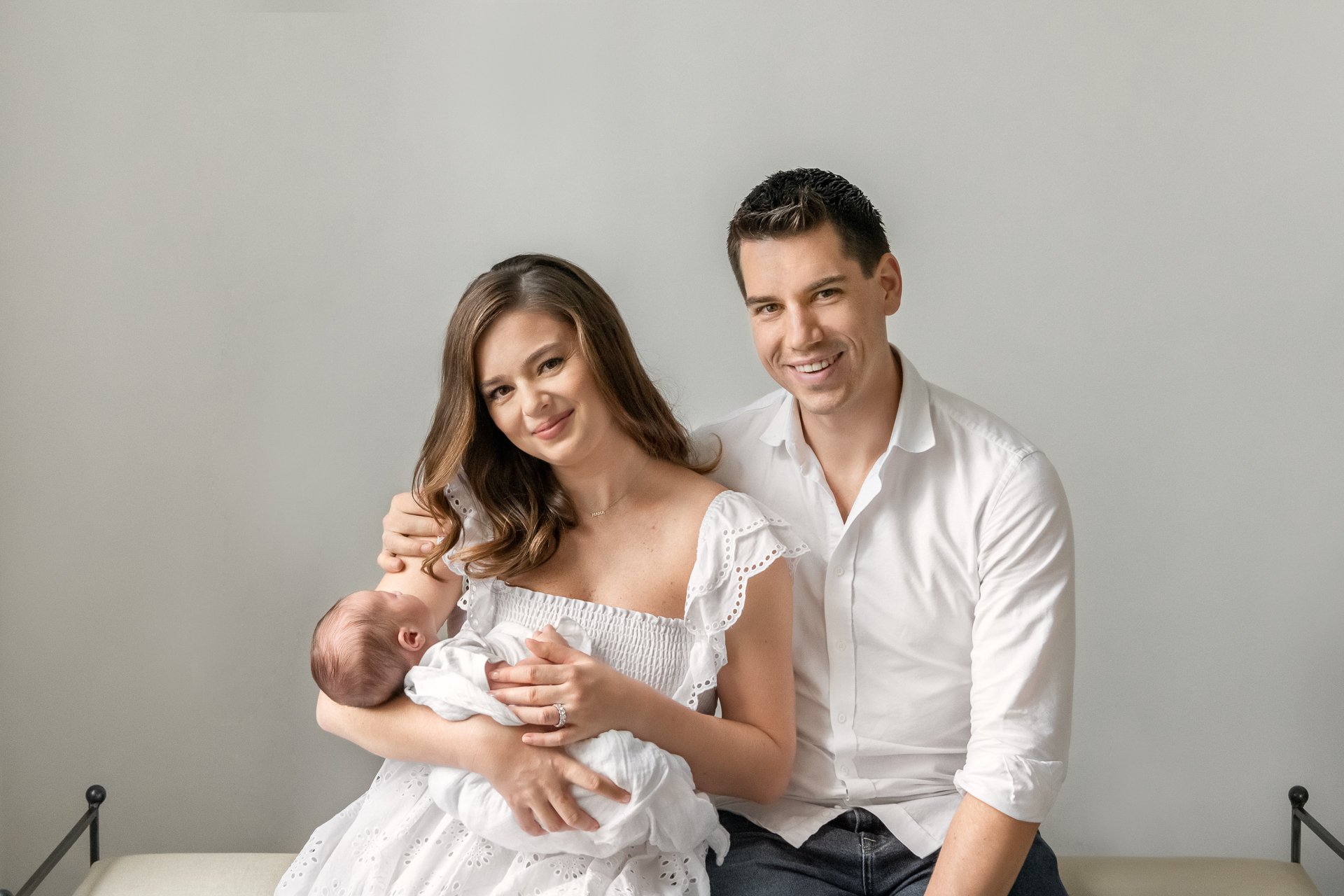  NY photographer Nicole Hawkins Photography captures a new family of three in white at a bright light studio. new parents fresh 48 portraits #nicolehawkinsphotography #NYCbabyphotography #newbornportraits #NewYorkStudioPhotography #newbornsession 