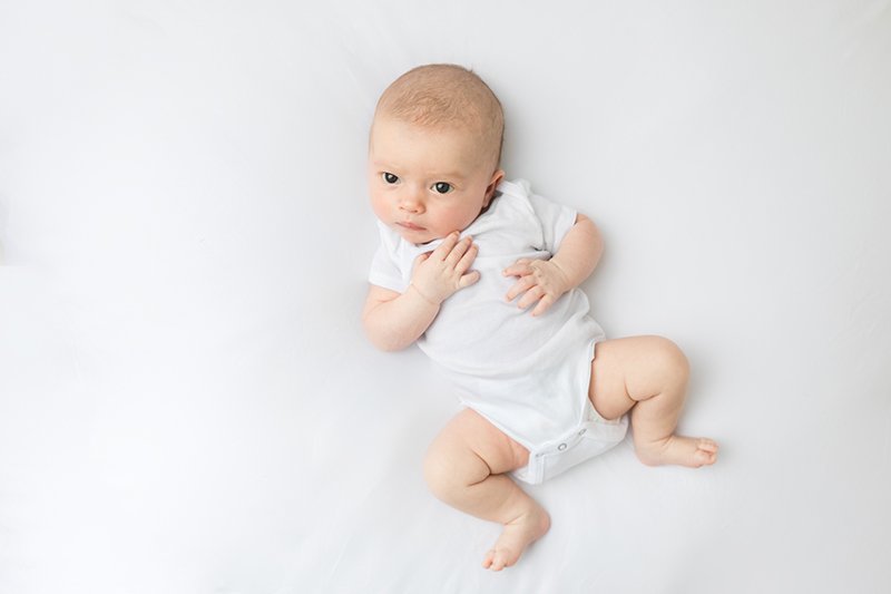  Sweet baby girl in a white onesie at a studio in New Jersey by Nicole Hawkins Photography. simple all-white baby photos NJ newborn #nicolehawkinsphotography #NJstudionewborns #newbornsession #studionewborns #NJnewbornphotographers #NJphotographers 