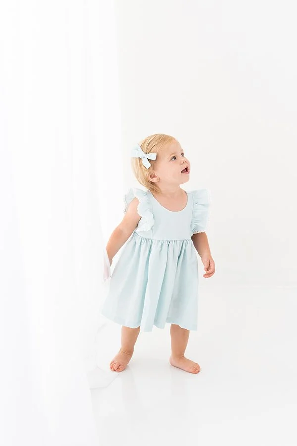  At a studio in New Jersey, a baby girl in a blue dress walks around captured by Nicole Hawkins Photography. baby girl studio session #nicolehawkinsphotography #NJstudioportraits #babyportraits #babygirlportraits #NJbabyphotographers #NJphotographers