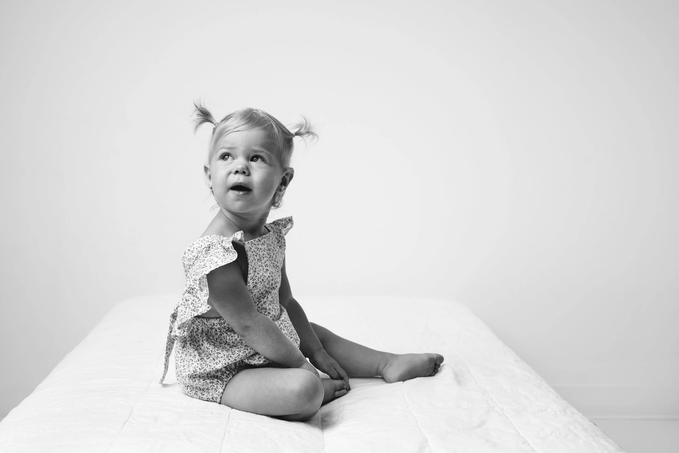  At an NJ family photography studio, Nicole Hawkins Photography captures a baby girl in a floral romper. baby girl style black and white baby pic #nicolehawkinsphotography #NJstudioportraits #babyportraits #NJbabyphotographers #NJphotographers 