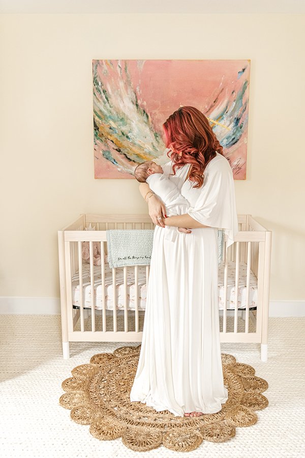  In a modern neutral baby nursery, a mother holds her baby captured by Nicole Hawkins Photography. modern baby nursery neutral crib #nicolehawkinsphotography #NJfamilyphotographer #inhomenewbornsession #nicolehawkinsnewborns #NJnewbornphotography 