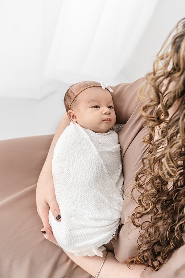  Nicole Hawkins Photography captures a baby girl in her mother's arms during a studio portrait session. studio portrait NJ swaddled baby #NicoleHawkinsPhotography #studionewbornportraits #NJstudiophotographer #NJnewborns #NicoleHawkinsNewborns 