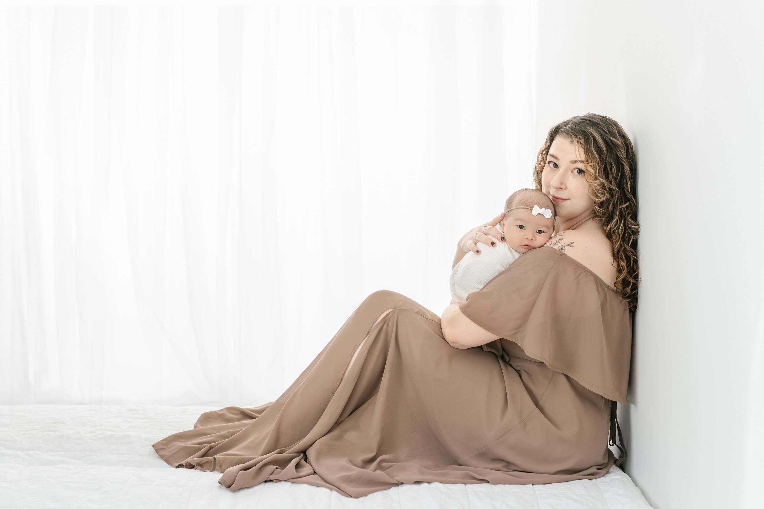  A bright-eyed baby girl snuggles her mother in a studio in New Jersey by Nicole Hawkins Photography. baby snuggles eyes open baby portrait #NicoleHawkinsPhotography #studionewbornportraits #NJstudiophotographer #NJnewborns #NicoleHawkinsNewborns 