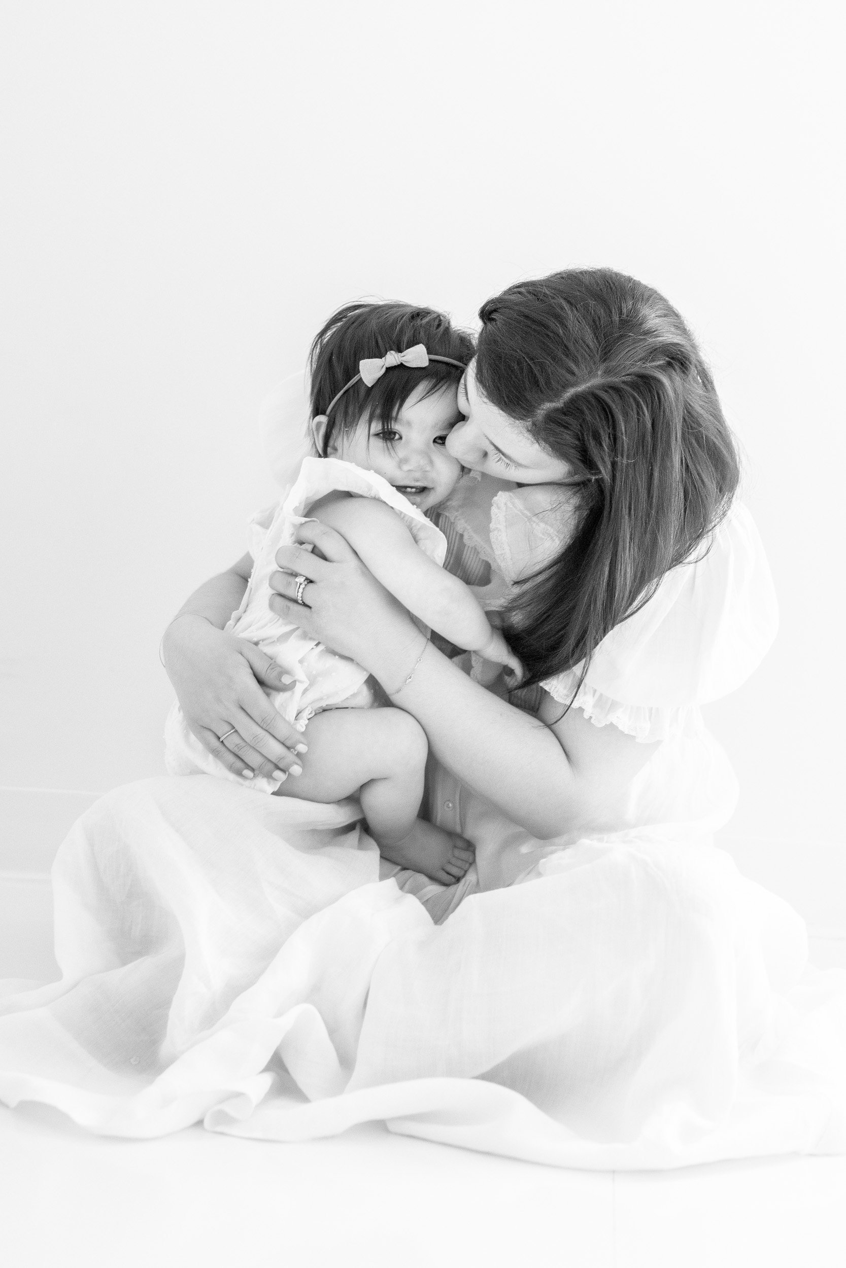  Nicole Hawkins Photography an NJ baby photographer captures a mother kissing her baby girl during a milestone session. mommy kisses milestones #nicolehawkinsphotography #nicolehawkinsbirthday #nicolehawkinsportraits #NJstudiophotography #1stbirthday