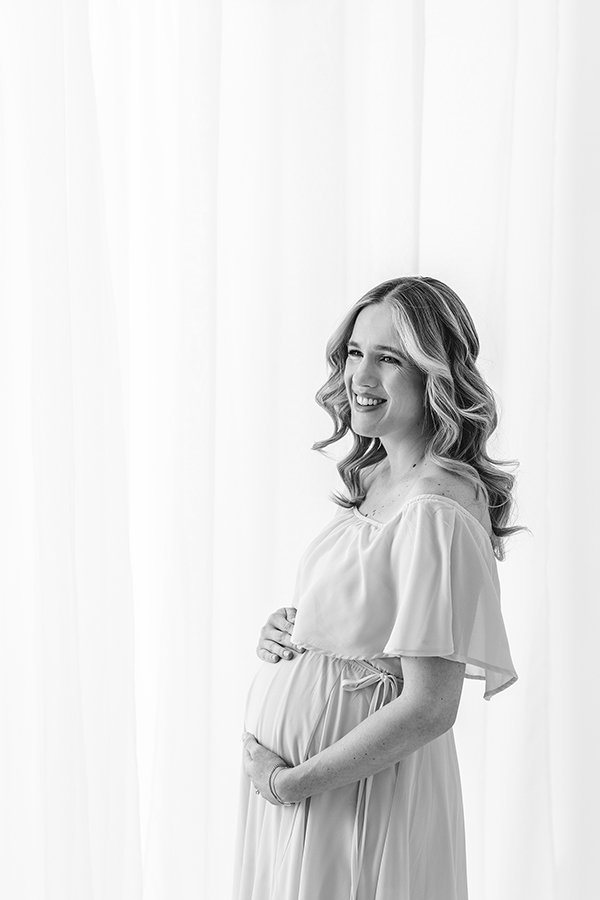  A black and white maternity portrait was taken in a studio by Nicole Hawkins Photography. maternity outfits off the shoulder maternity dress #nicolehawkinsphotography #nicolehawkinsmaternity #maternityportraits #NJstudiophotography #mommatobe 