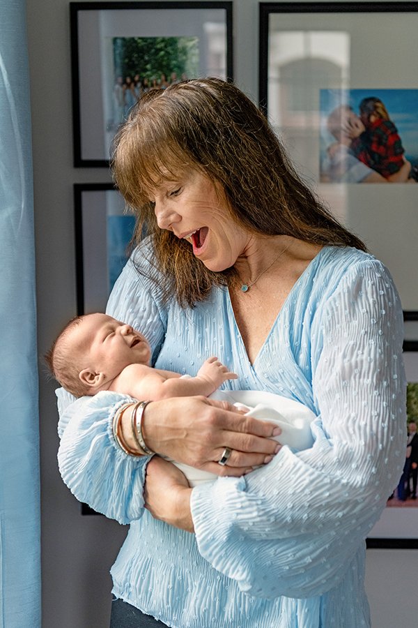  Grandma holds her grandson in front of a bright light window by Nicole Hawkins Photography. grandma and baby grandbabies #NewbornSession #NJfamilyphotographer #Inhomebabyphotography #newborn #NicoleHawkinsPhotography #NicoleHawkinsNewborns 