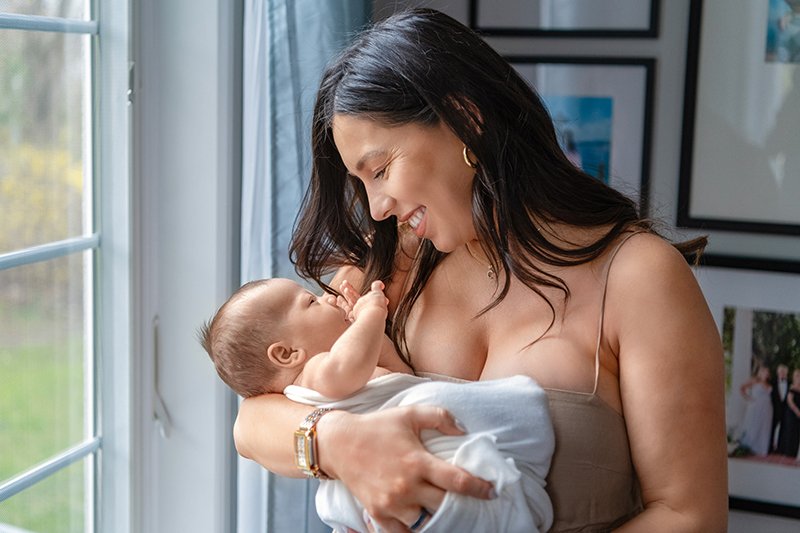  During an at-home session, a mother interacts sweetly with a newborn boy by Nicole Hawkins Photography. New Jersey newborns #NewbornSession #NJfamilyphotographer #Inhomebabyphotography #newborn #NicoleHawkinsPhotography #NicoleHawkinsNewborns 