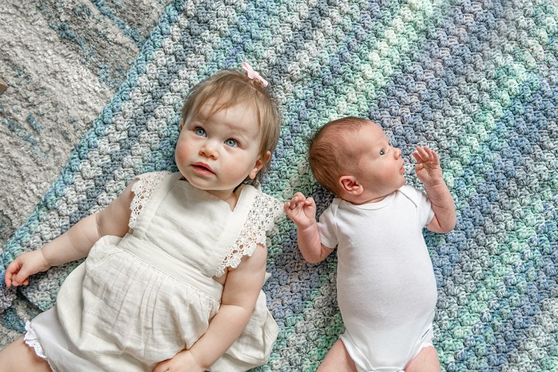  A toddler older sister lays down with her newborn brother in New Jersey with Nicole Hawkins Photography. toddler little girl #NewbornSession #NJfamilyphotographer #Inhomebabyphotography #newborn #NicoleHawkinsPhotography #NicoleHawkinsNewborns 