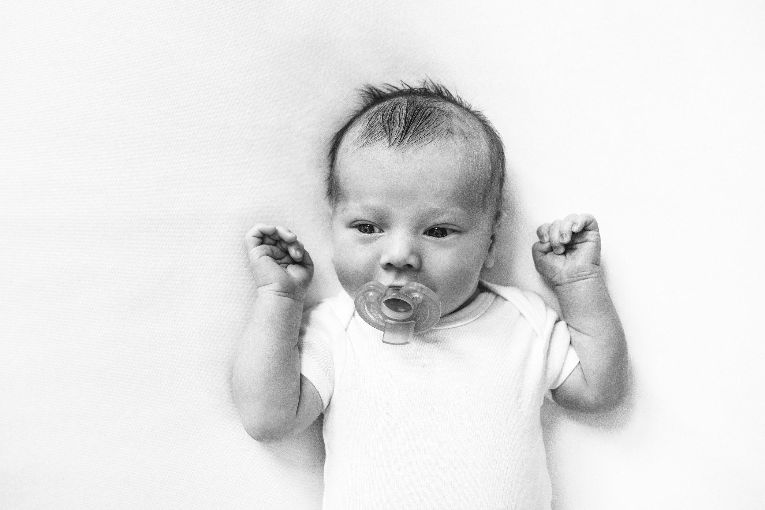  New Jersey family photographer Nicole Hawkins Photography captures a portrait of a newborn with a binkie in his mouth. binkie portrait #NewbornSession #NJfamilyphotographer #Inhomebabyphotog #newborn #NicoleHawkinsPhotography #NicoleHawkinsNewborns 