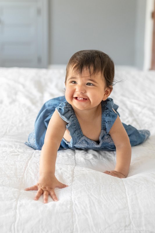  Happy baby girl crawling on a white bedspread at an in-home portrait session in Glen Ridge, New Jersey. #newjersyphotographers #njfamilyphotoographer #nicolehawkinsphotography #nicolehawkinsfamilies #inhomeportraits #glenridge #newjersey #babygirl 