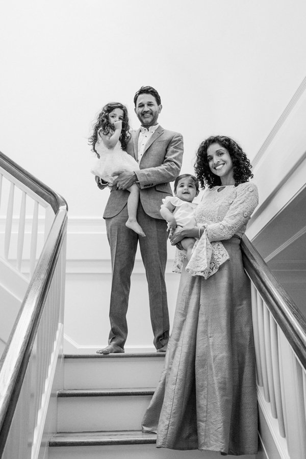  Family of four standing on the stairs and smiling, with mom and dad each holding a beautiful daughter. #familyportraits #newjersyphotographers #familyoffour #njfamilyphotoographer #nicolehawkinsphotography #nicolehawkinsfamilies #glenridge #newjerse