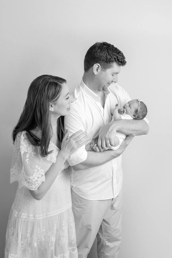  Black and white portrait of a mom and dad holding their newborn baby girl in their New Jersey home. #nicolehawkinsnewborns #njfamilyphotographer #chatham #newjersey #newbornfamilyportraits #nicolehawkinsphotography #inhomeportraits #secondtimeparent