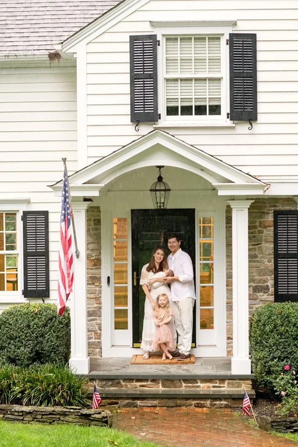  Family posed on the front steps of their new home in Chatham, New Jersey with their toddler and baby. #newbornfamilyportraits #familyoffour #nicolehawkinsphotography #inhomephotography #njfamilyphotographer #chatham #newjersey #nicolehawkinsnewborns