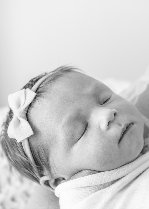  Black and white portrait of a beautiful baby girl swaddled in a blanket and wearing a sweet bow headband. #newbornbaby #babygirl #newborndetails #familyportraits #nicolehawkinsphotography #nicolehawkinsnewborns #chatham #newjersey #inhomeportraits 