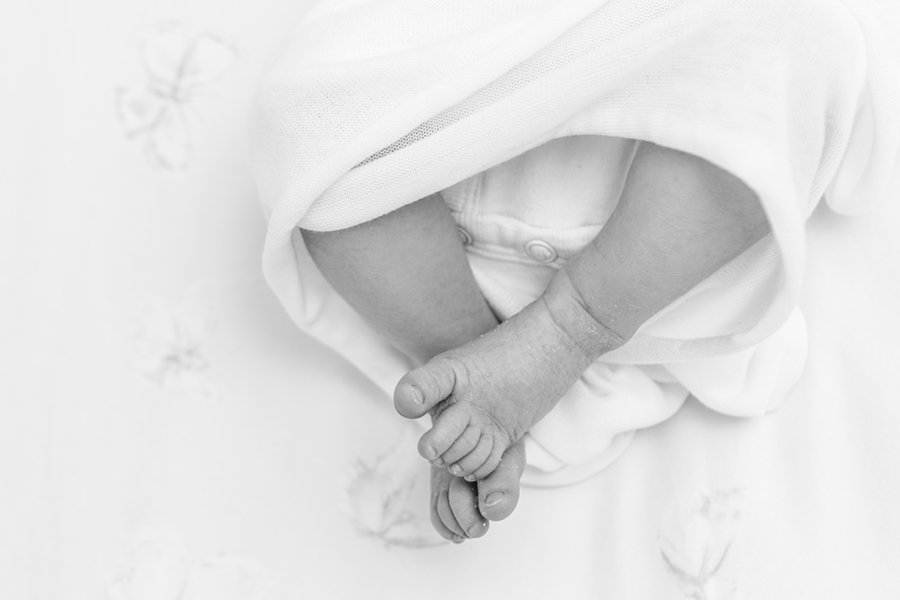  Black and white closeup photo of precious baby girl toes poking out of the swaddle. black and white photo #newbornbaby #babygirl #newborndetails #familyportraits #nicolehawkinsphotography #nicolehawkinsnewborns #chatham #newjersey #inhomeportraits 