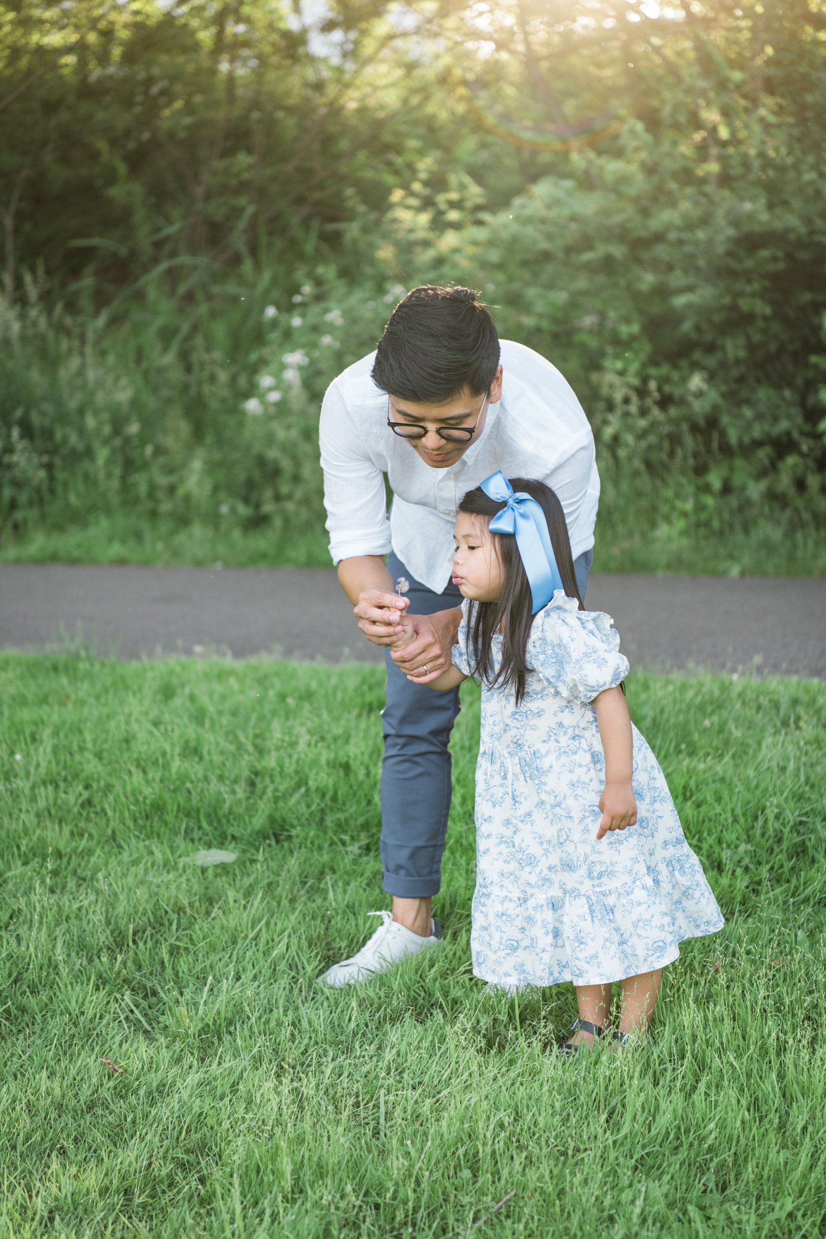  Dad helps his daughter blow a dandelion during a family portrait session in Westfield NJ #seniorportraits #familyportraits #veronanj #westfieldnj #nicolehawkinsphotography #newjerseyphotographer  #portraitphotography #heirloomphotography 