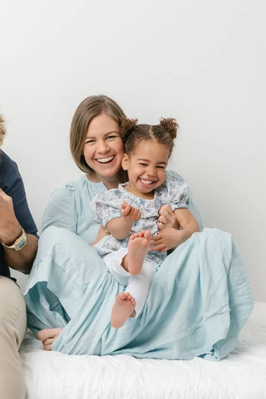  Family Photographer Nicole Hawkins Photography captures a mother and daughter in light blue dresses laughing together. biracial family photo #NicoleHawkinsPhotography #NicoleHawkinsBabies #StudioPhotography #NewJerseyPhotographer #twinphotography   