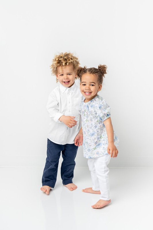  New Jersey photographer captured a bright airy portrait of twins smiling in a white studio by Nicole Hawkins Photography. twin portrait two #NicoleHawkinsPhotography #NicoleHawkinsBabies #StudioPhotography #NewJerseyPhotographer #twinphotography   