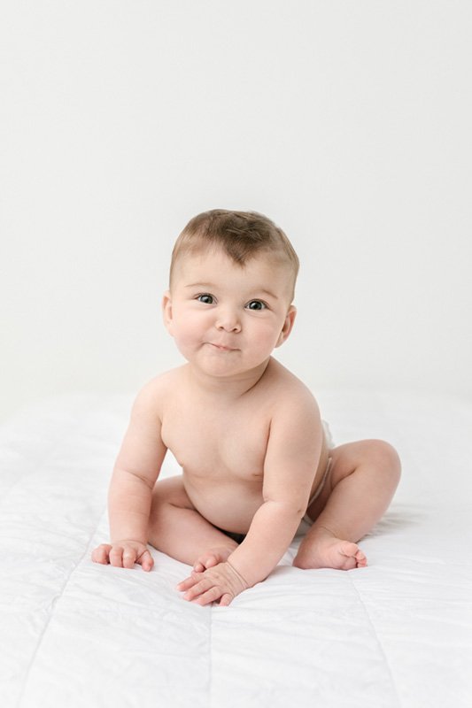  Nicole Hawkins Photography a baby photographer in New Jersey takes a portrait of a naked baby in a white studio. white studio portraits NJ #sixmonthbabyportraits #NJPhotographer #NicoleHawkinsPhotography #NicoleHawkinsBabies #BabyStudioPhotography  