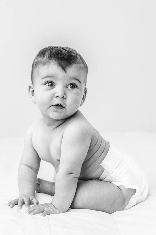  Black and white portrait of a naked baby in a diaper in a studio by Nicole Hawkins Photography. black and white portrait of baby #sixmonthbabyportraits #NJPhotographer #NicoleHawkinsPhotography #NicoleHawkinsBabies #BabyStudioPhotography    