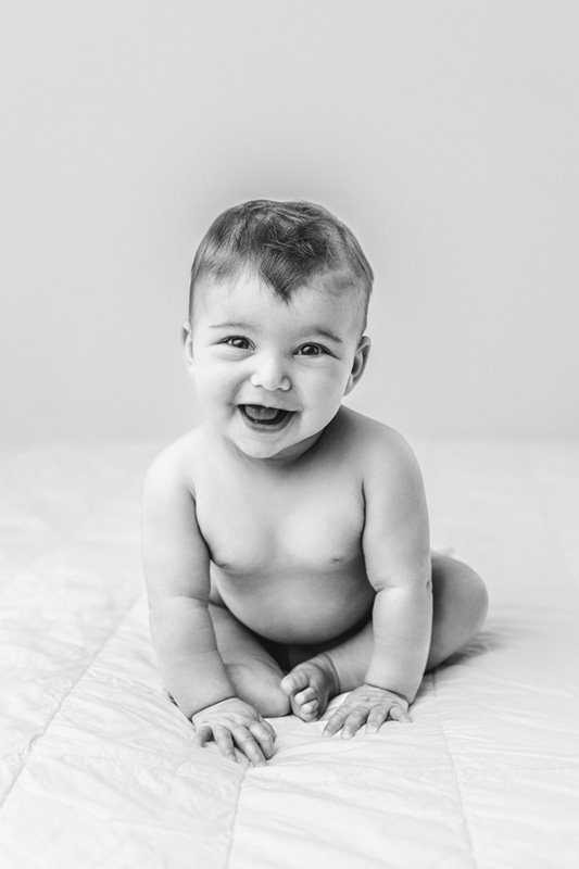  Portrait in black and white of a smiling little girl captured by Nicole Hawkins Photography. NJ professional photographer sitter session #sixmonthbabyportraits #NJPhotographer #NicoleHawkinsPhotography #NicoleHawkinsBabies #BabyStudioPhotography    