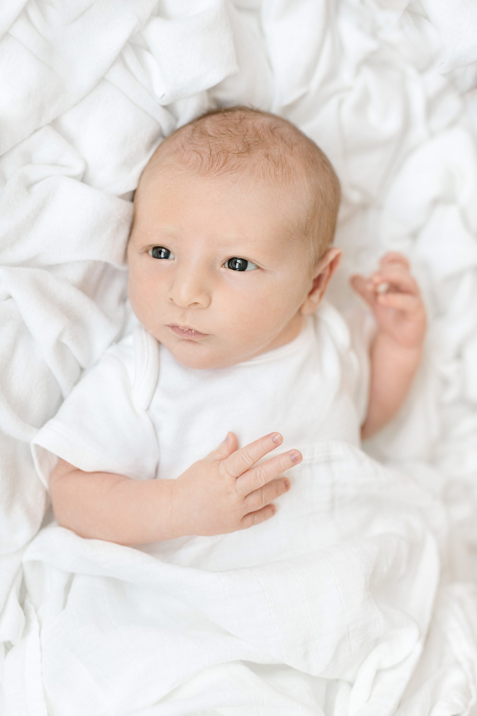  At an In-Home Newborn Session, Nicole Hawkins Photography captures a baby boy with his eyes wide open. newborn with open eyes #NicoleHawkinsPhotography #InHomeNewborn #JerseyShoreNewborns #MontclairPhotographers #NewbornPhotography #baby #newborn 