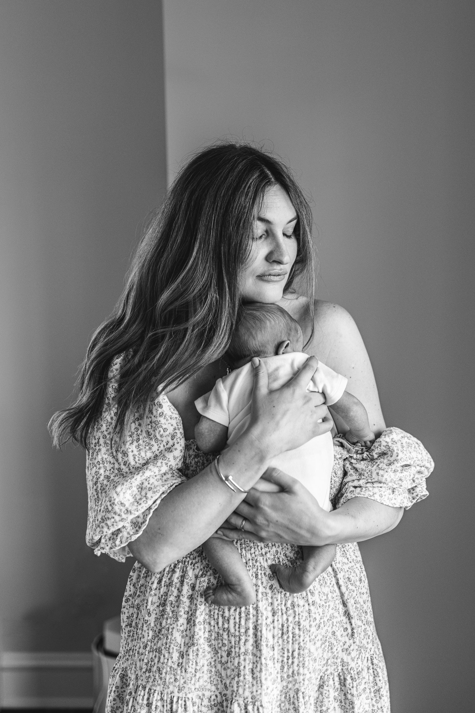  Nicole Hawkins Photography captures a black and white portrait of a new mother holding her baby boy. mother and baby moments #NicoleHawkinsPhotography #InHomeNewborn #JerseyShoreNewborns #MontclairPhotographers #NewbornPhotography #baby #newborn 