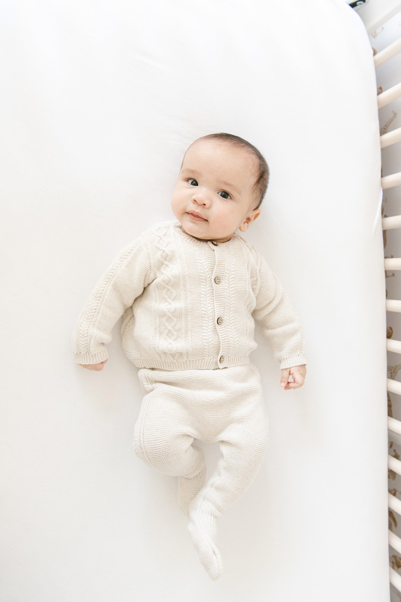  A baby boy in his crib during an In-home Newborn session with Nicole Hawkins Photography in New York. baby in a crib #NicoleHawkinsPhotography #InHomeNewborns #NurseryNewborns #NYCbabyphotography #babyportraits #ZooNursery #familyportraits 