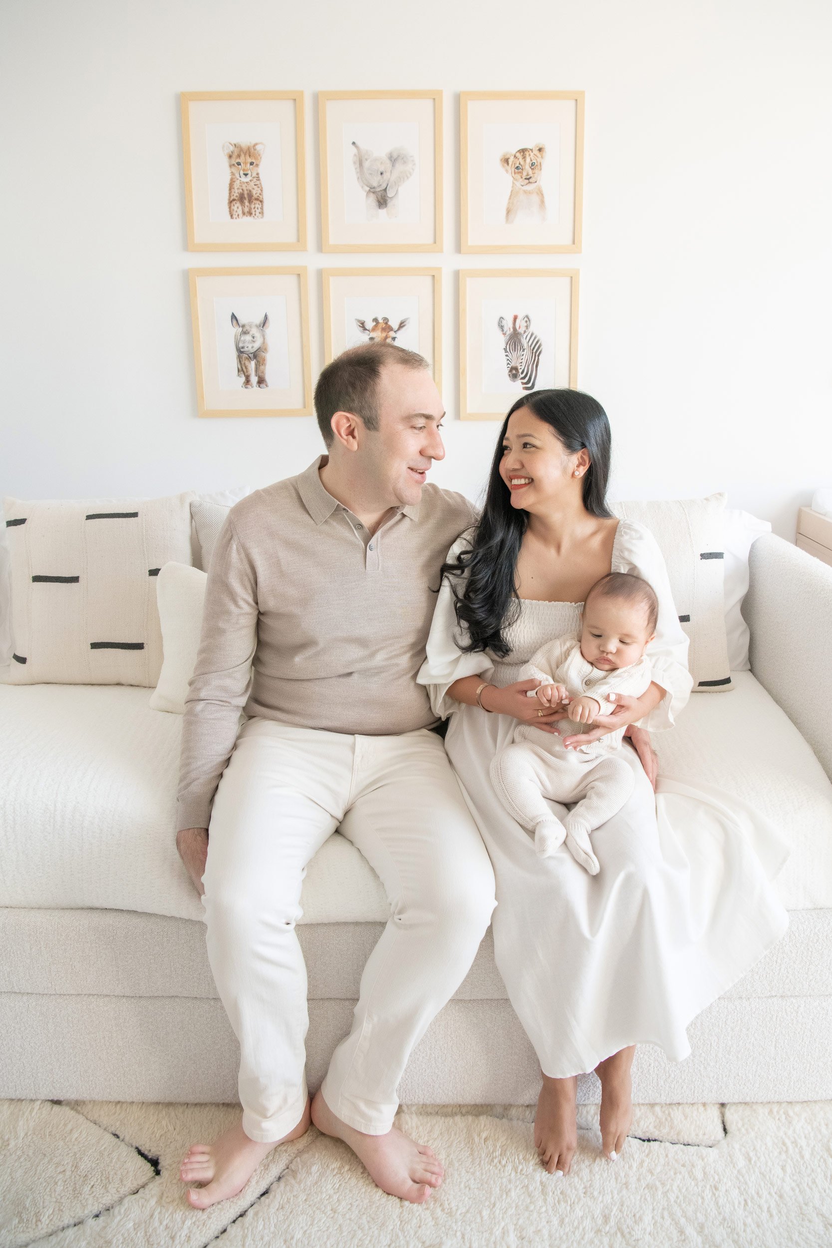  In a zoo-themed nursery, a family snuggles together on the couch by Nicole Hawkins Photography. family portrait #NicoleHawkinsPhotography #InHomeNewborns #NurseryNewborns #NYCbabyphotography #babyportraits #ZooNursery #familyportraits 